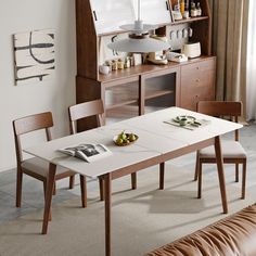 a dining room table with two chairs and a magazine on the table next to it