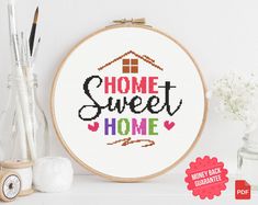 a cross stitch pattern with the words home sweet home on it, next to some craft supplies