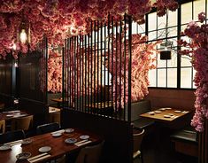 the interior of a restaurant decorated with pink flowers