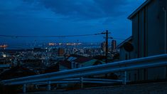 the city is lit up at night with lights in the distance and buildings on either side