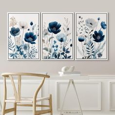 two blue and white flowers are hanging on the wall next to a chair in a room