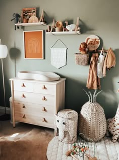 a baby's room with green walls and white furniture, including a crib