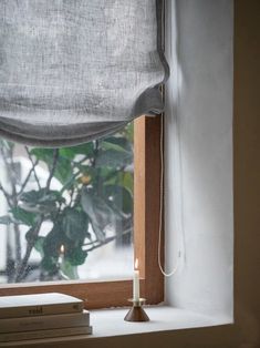 a window sill with books and a candle on it