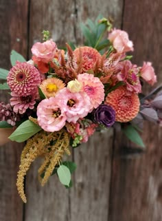 a bouquet of flowers sitting on top of a wooden table