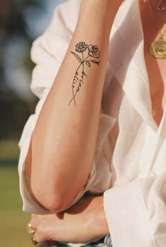 a woman with a flower tattoo on her arm