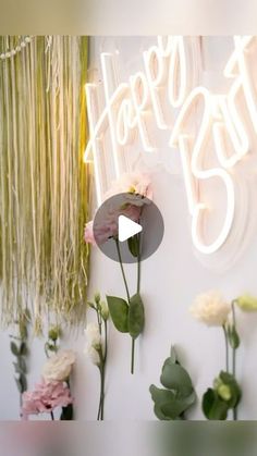 flowers and greenery are displayed in front of a happy birthday sign on the wall