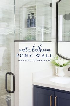 a bathroom with blue cabinets and a white sink in front of a large mirror on the wall