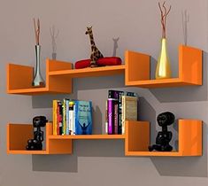 an orange shelf with books and vases on it