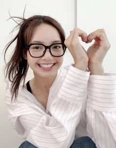 a woman wearing glasses and smiling at the camera