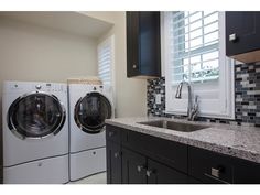 a washer and dryer sitting next to each other in a room with black cabinets