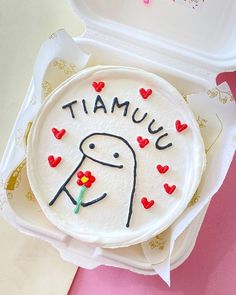 there is a cake in the box that says tamuuu with hearts on it