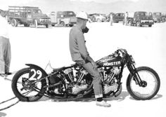 a man sitting on top of a motorcycle in the desert