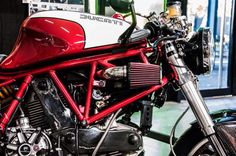 a red and white motorcycle parked in a garage