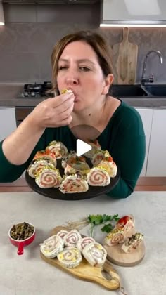 a woman sitting at a kitchen counter eating food from a plate on top of a table