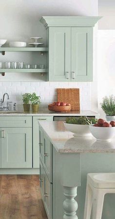 a kitchen with green cabinets and white counter tops