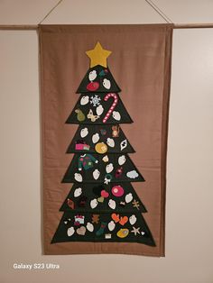 a christmas tree hanging on the wall with buttons attached to it's bottom half