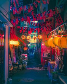 an alley way with lots of lights and signs hanging from it's ceilings