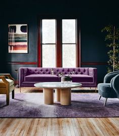 a living room with purple couches and chairs