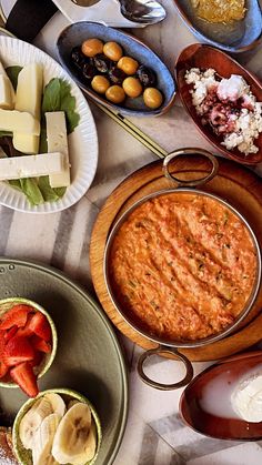 a table topped with plates and bowls filled with food