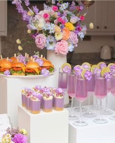 a table topped with lots of glasses filled with food