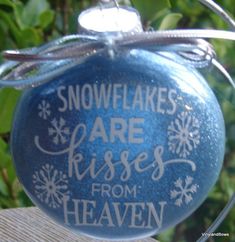 a blue ornament with snowflakes are kisses from heaven written on it