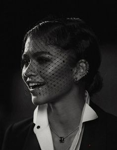 black and white photograph of a woman wearing a birdcage veil