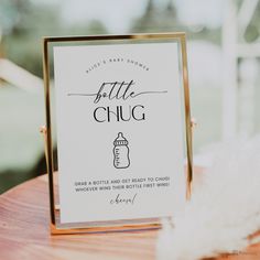 a baby shower sign sitting on top of a wooden table