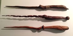 three old wooden wands sitting on top of a white table next to each other