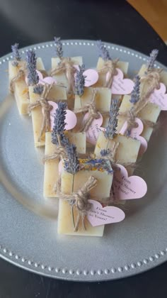 small pieces of soap sitting on top of a silver plate with tags attached to them