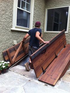 a man is moving some wood from his house