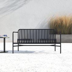 a black metal bench sitting next to a table