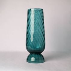 a green glass vase sitting on top of a table