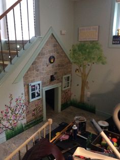 there is a dog house in the living room with its stairs up to the second floor