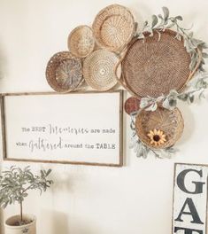 some baskets are hanging on the wall next to a potted plant and a sign