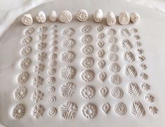 several different shapes and sizes of buttons on a white surface, with one being made out of clay