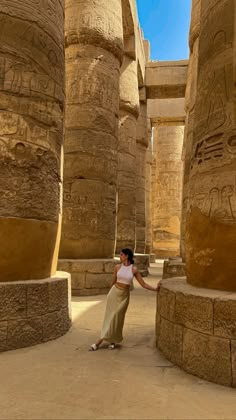 a woman standing in front of some very large columns at the egyptian museum, egypt