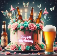 a birthday cake with beer bottles and flowers on it, surrounded by candles in the background