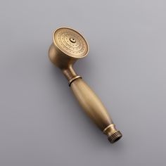 an antique brass shower head on a gray background