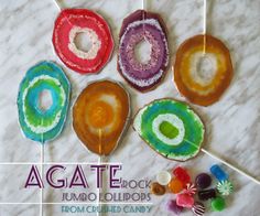 there are candy lollipops and candies on the table with text that reads agate rock jumbo lollipops