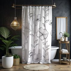 a white bath tub sitting next to a shower curtain with flowers on it in a bathroom