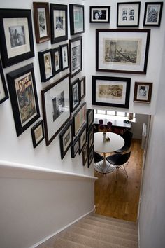 the wall is covered with many framed pictures