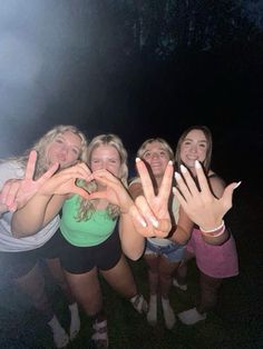 four girls making the v sign with their hands