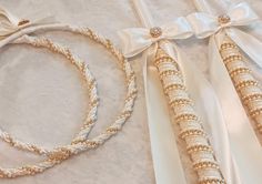 two white and gold wedding garters with bows on the top one is tied up