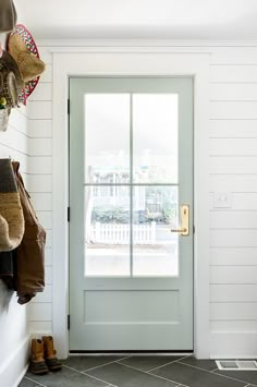 the front door is open and there are boots hanging on the wall next to it