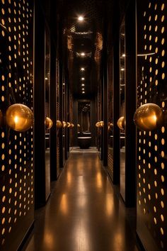 the hallway is lined with gold polka dot lights and black metal partitions, along with floor to ceiling mirrors