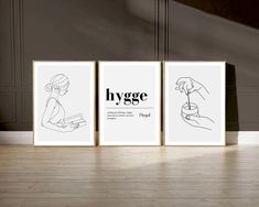 three black and white posters with the words hygge on them in front of a wooden floor