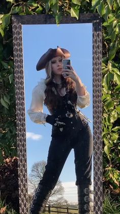 a woman is taking a selfie in front of a mirror with her hat on