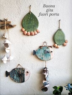 three different types of sea glass hanging on the wall next to a potted plant