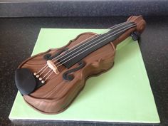 a cake made to look like a violin on top of a green sheet that is sitting on a table