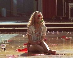 a woman sitting on the ground with her mouth open